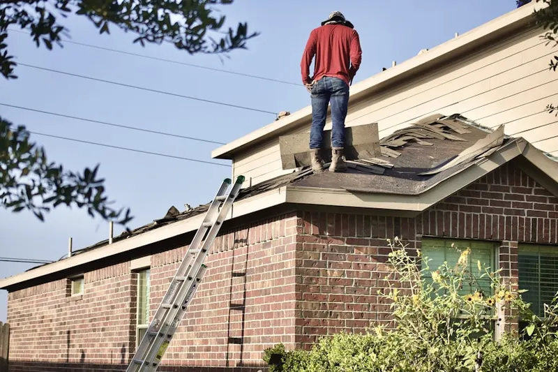 Professional roofer working on a residential roof in Southern Mattapan